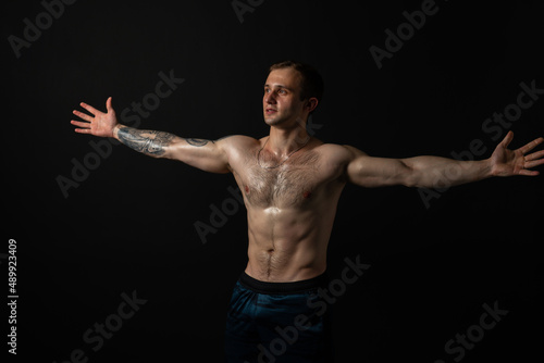 Man on black background keeps dumbbells pumped up in fitness muscle sexy body weight workout lifting powerful, person weightlifting. Young sportive adult, people fit
