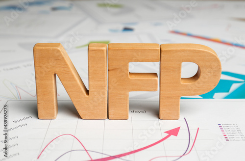 Wooden letters NFP on documents with charts photo