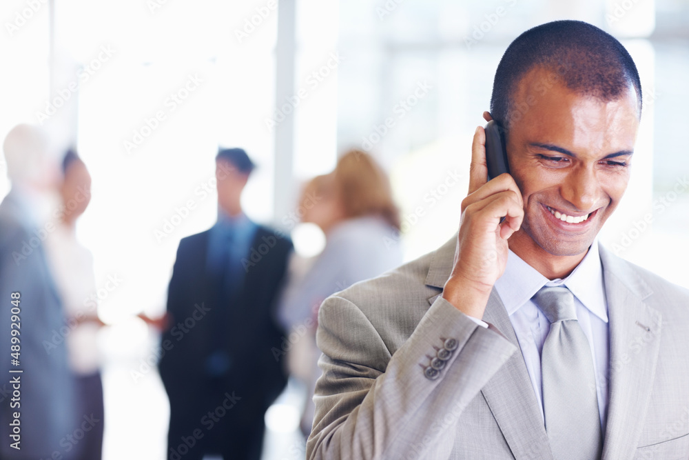 Happy African American business man on call. Portrait of happy African American business man on call with associates in background. Happy African American business man on call. Portrait of happy African American business man on call with associates in background.
