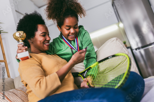 Proud mother feel so excited to see her daughter  medal and trophy in her hand after tennis tournament. photo