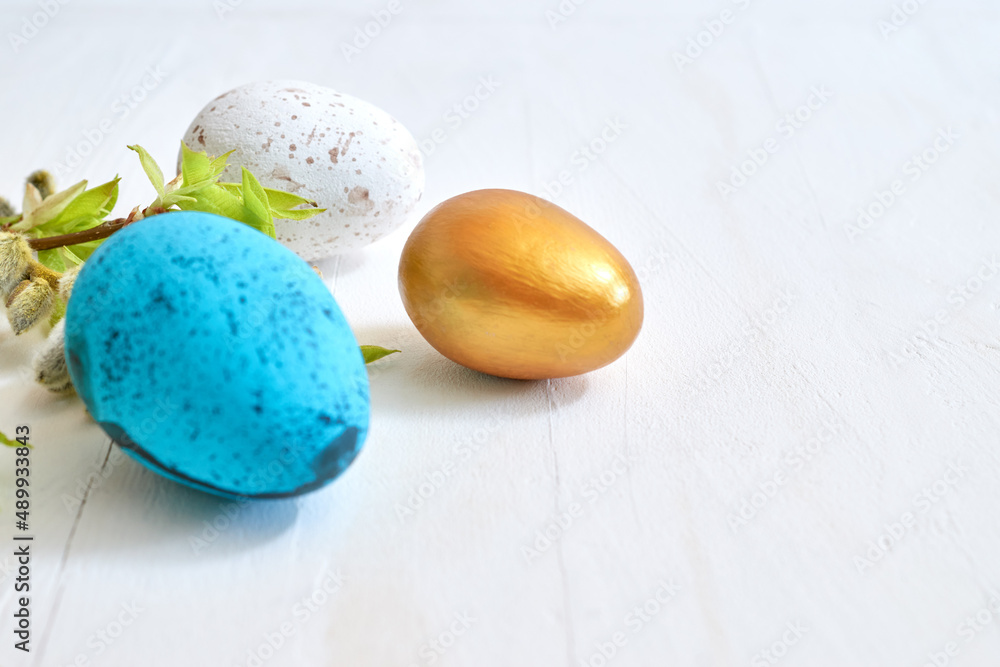 Branches with buds and green leaves, easter eggs on a light background. Happy easter concept with copy space Branches with buds and green leaves, easter eggs on a light background. Happy easter concept with copy space