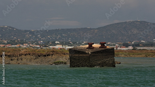 Photography Rusty bollards-concrete block-detached piece of jetty-Ria Formosa-St-Michael hill background