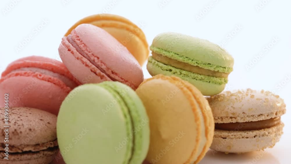 Close up of multicolor macarons French macaroon greedy pastry rotate on white background. Macarons dessert. Food concept Close up of multicolor macarons French macaroon greedy pastry rotate on white background. Macarons dessert. Food concept