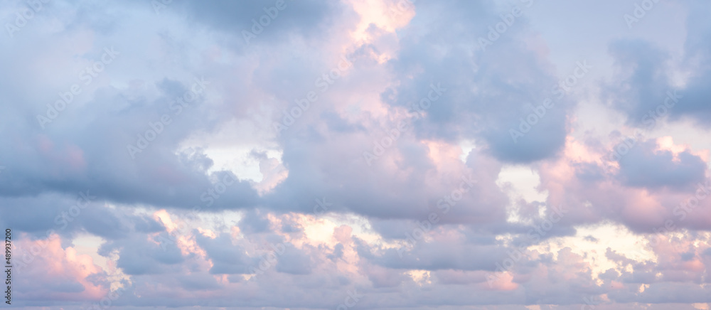 Pink and blue fluffy clouds at sunset
