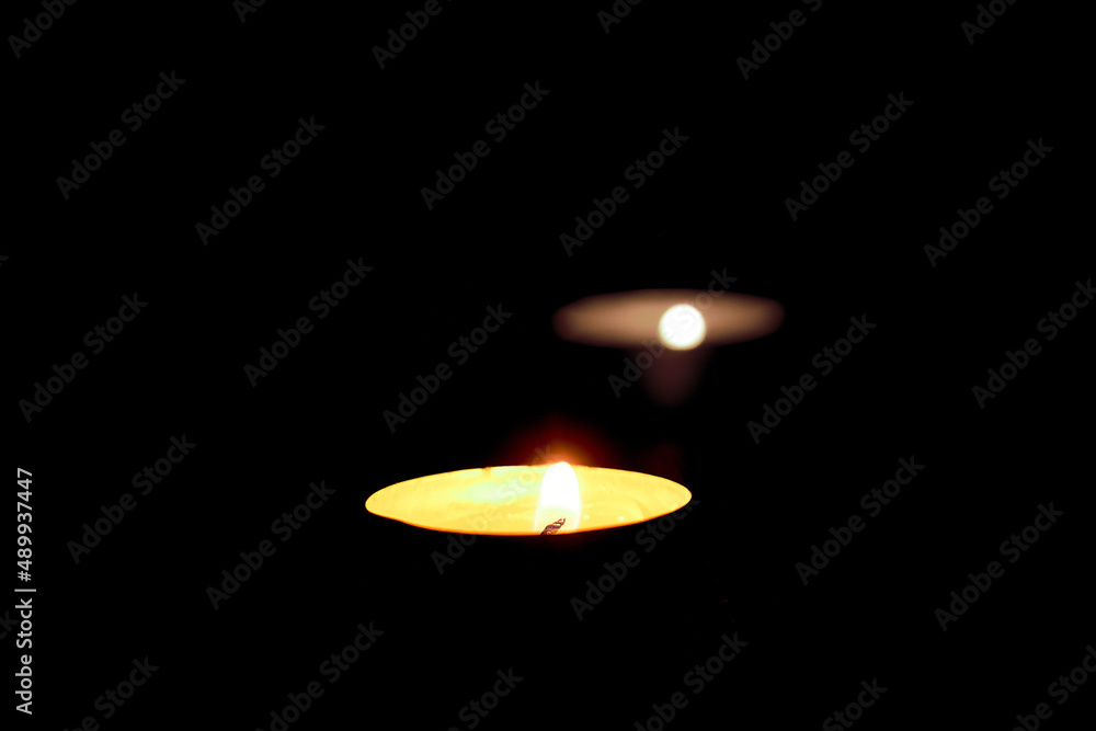 Two burning candles on the table in honor of the commemoration in the dark.Oppressive atmosphere Two burning candles on the table in honor of the commemoration in the dark.Oppressive atmosphere