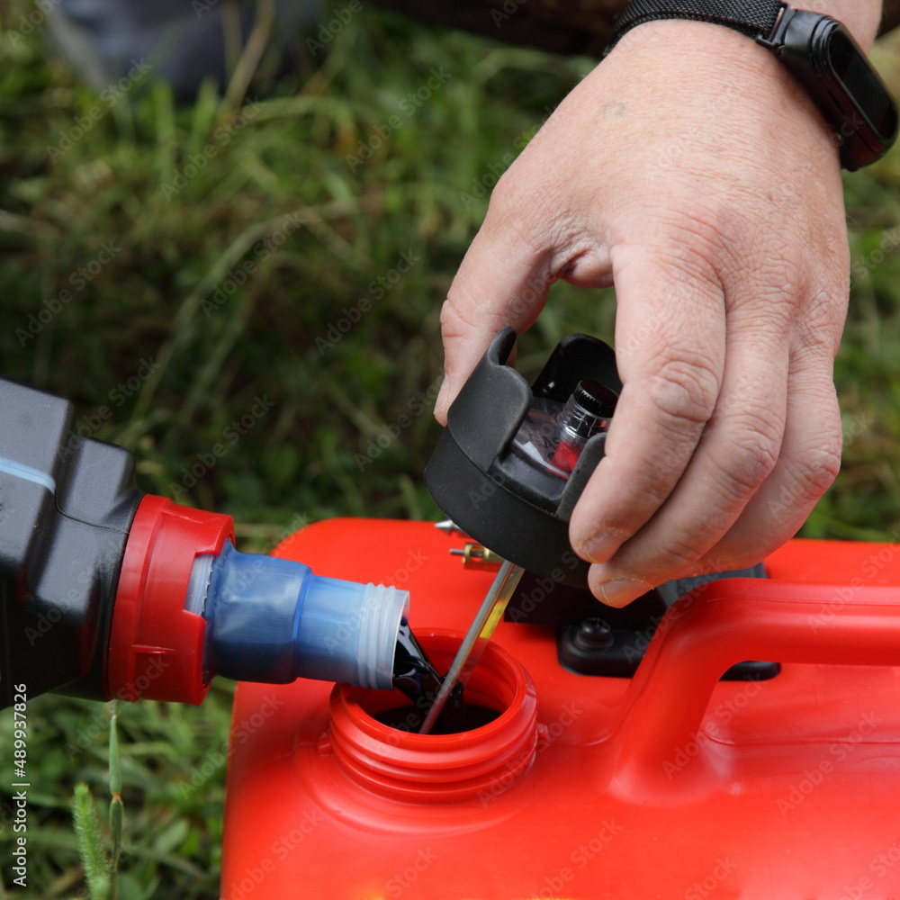 Adding special 2 T motor oil for twostroke engines to the gas tank for boat outboard motor from