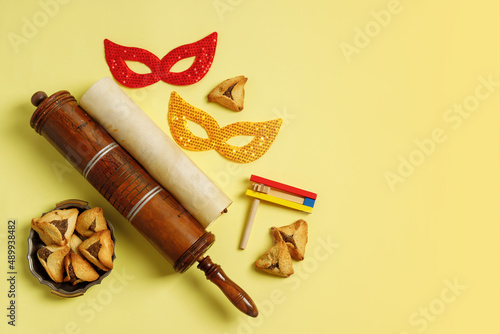 Purim Festival objects and Scroll of Esther on Yellow background. photo