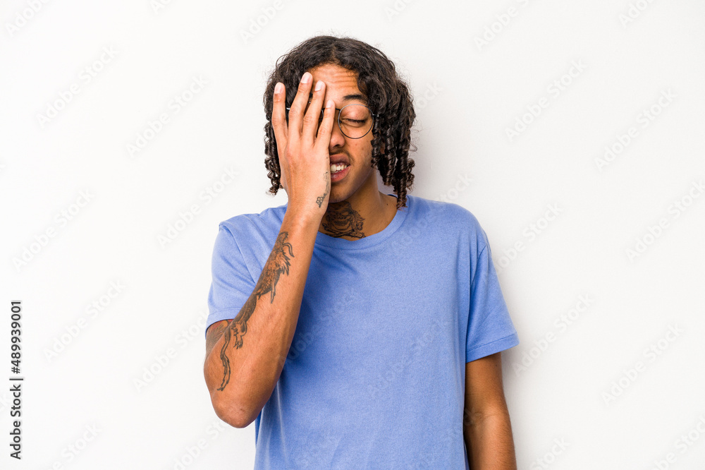Young African American man isolated on white background having fun covering half of face with palm. Young African American man isolated on white background having fun covering half of face with palm.