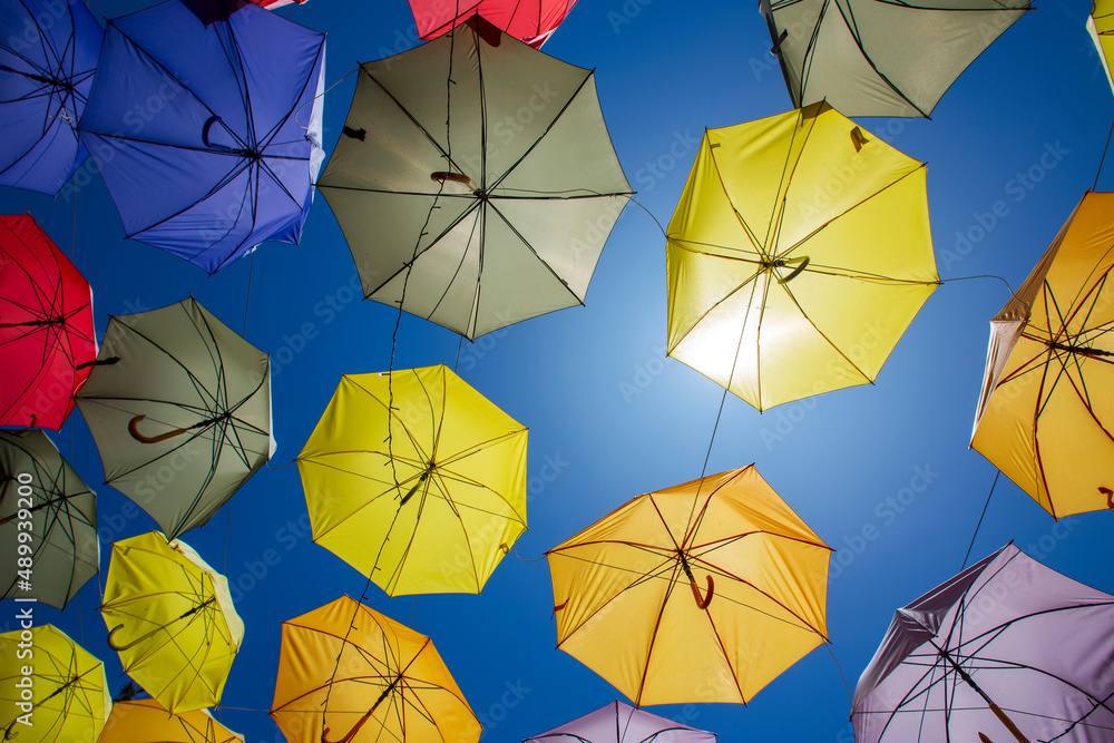 Colored umbrellas hung above street Colored umbrellas hung above street