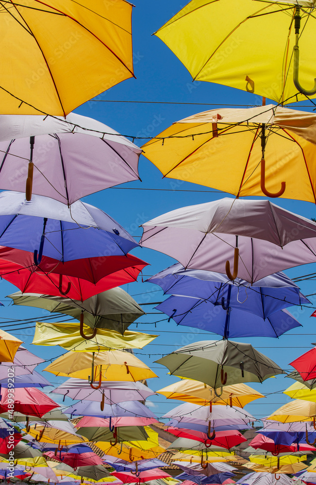 Colored umbrellas hung above street Colored umbrellas hung above street