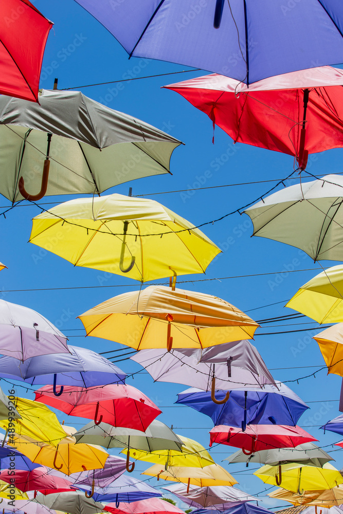 Colored umbrellas hung above street Colored umbrellas hung above street