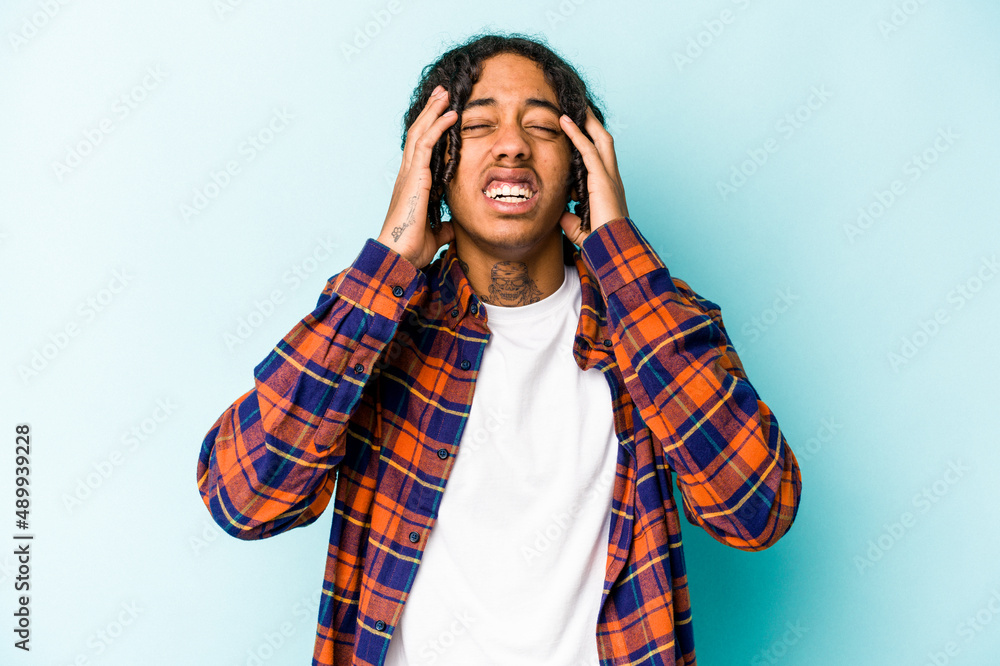 Young African American man isolated on blue background whining and crying disconsolately. Young African American man isolated on blue background whining and crying disconsolately.