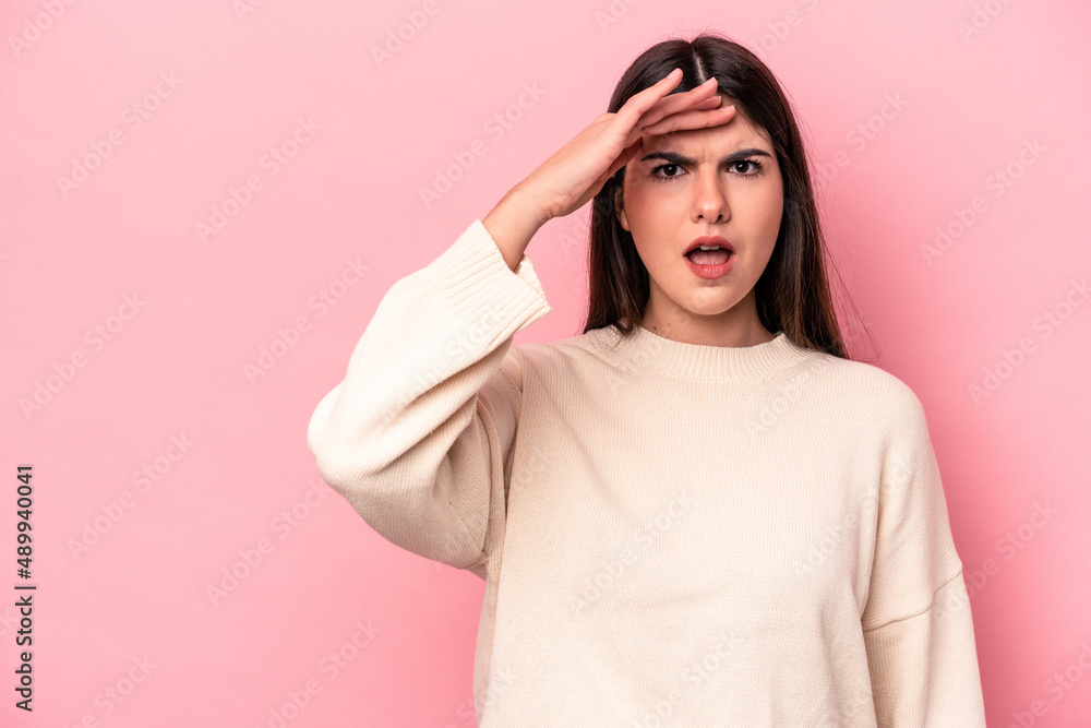 Young caucasian woman isolated on pink background shouts loud, keeps eyes opened and hands tense. Young caucasian woman isolated on pink background shouts loud, keeps eyes opened and hands tense.
