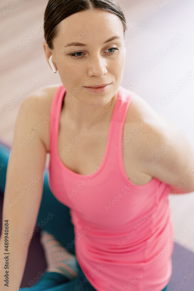 Attractive woman practicing yoga at home using online training instructions Attractive woman practicing yoga at home using online training instructions