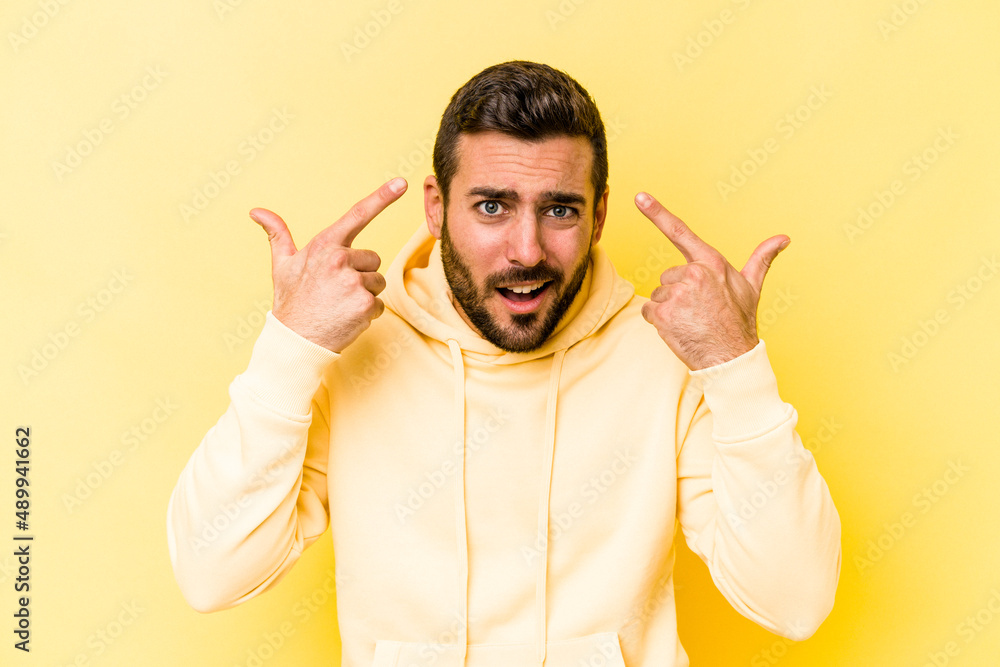 Young caucasian man isolated on yellow background showing a disappointment gesture with forefinger. Young caucasian man isolated on yellow background showing a disappointment gesture with forefinger.