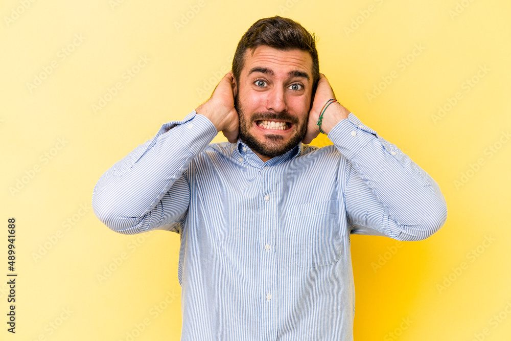 Young caucasian man isolated on yellow background screaming with rage. Young caucasian man isolated on yellow background screaming with rage.