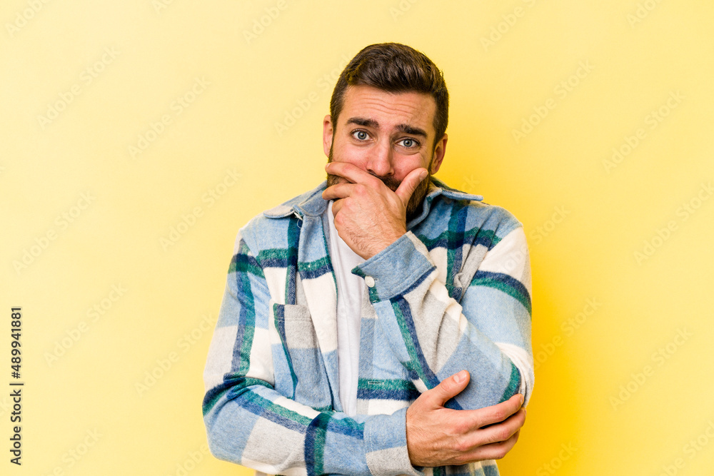 Young caucasian man isolated on yellow background scared and afraid. Young caucasian man isolated on yellow background scared and afraid.