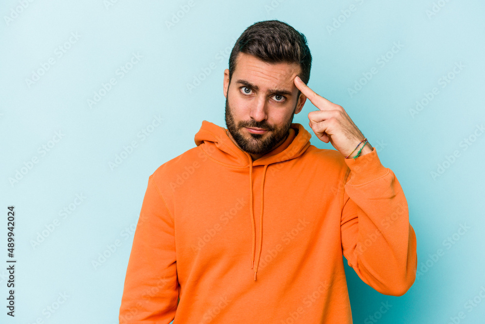 Young caucasian man isolated on blue background pointing temple with finger, thinking, focused on a task. Young caucasian man isolated on blue background pointing temple with finger, thinking, focused on a task.