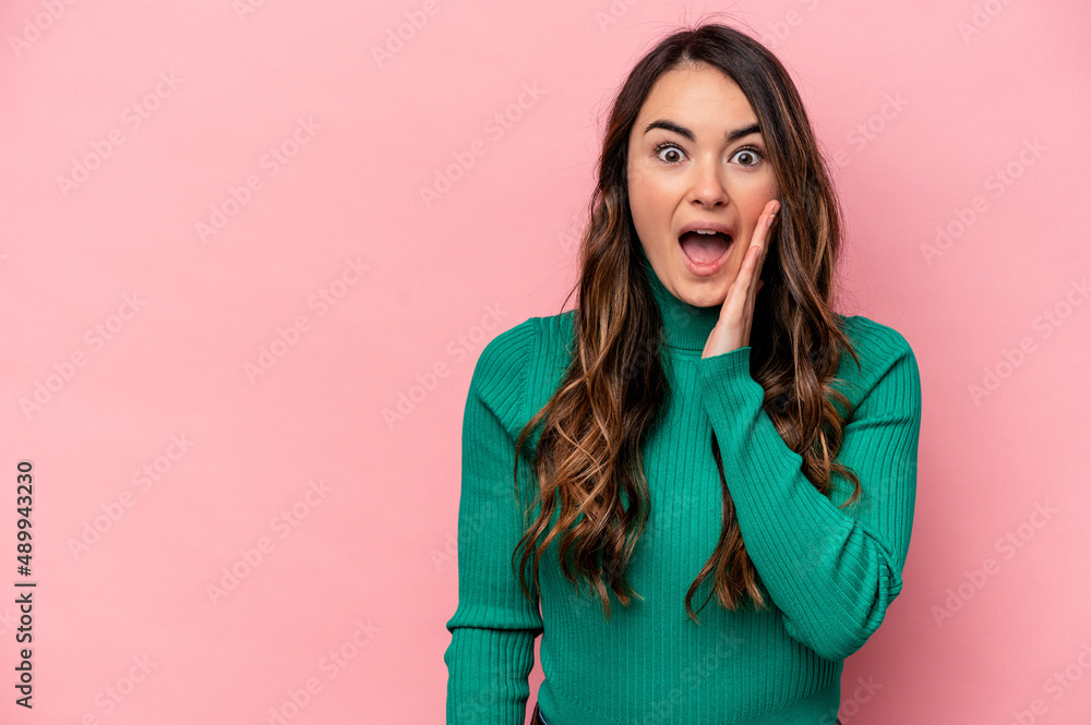 Young caucasian woman isolated on pink background shouts loud, keeps eyes opened and hands tense. Young caucasian woman isolated on pink background shouts loud, keeps eyes opened and hands tense.