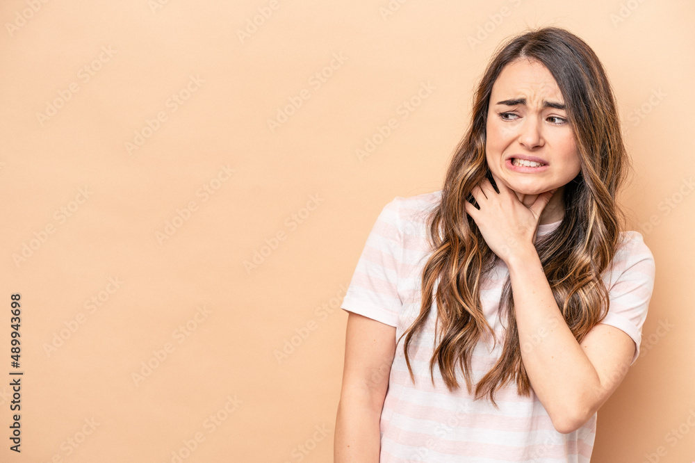 Young caucasian woman isolated on beige background touching back of head, thinking and making a choice. Young caucasian woman isolated on beige background touching back of head, thinking and making a choice.