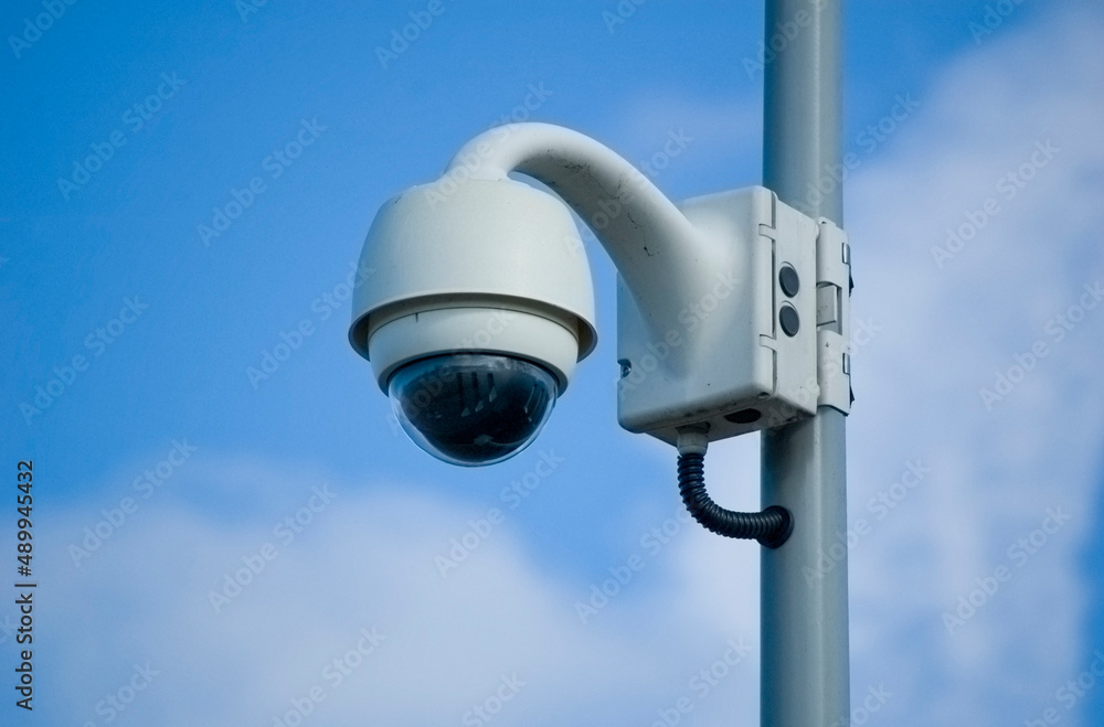 City monitoring system camera against blue sky.