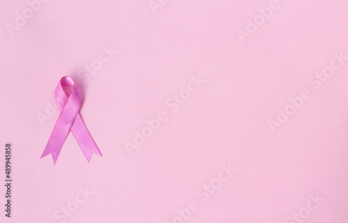 Pink ribbon on pink background with space for text. Women's day concept and breast cancer awareness 