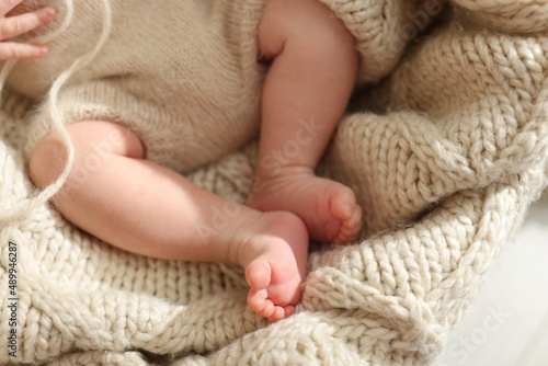 Adorable newborn baby on knitted plaid, closeup