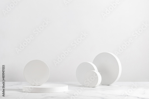 Podiums. White round podiums for presentation. Beauty pedestal on white background. © Maria