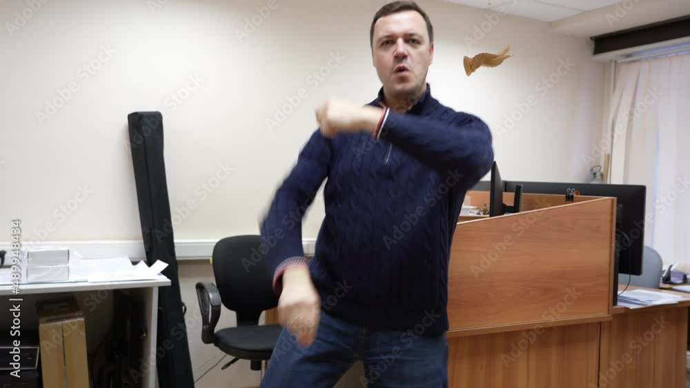 Successful businessman dances and celebrates his triumph in office behind workplace, excited about successful project. Joyful man celebrating achievement with dance moves and feeling happy about win Successful businessman dances and celebrates his triumph in office behind workplace, excited about successful project. Joyful man celebrating achievement with dance moves and feeling happy about win