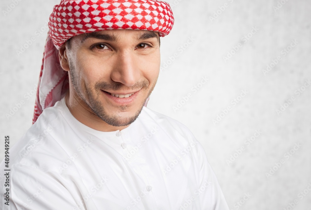 Young handsome Emirati business man in traditional outfit. Arabic ambitious mature businessman.