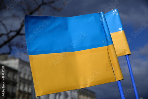 Ukrainan flags against dark blue sky during public demonstration to support Ukraine invaded by Russia photo