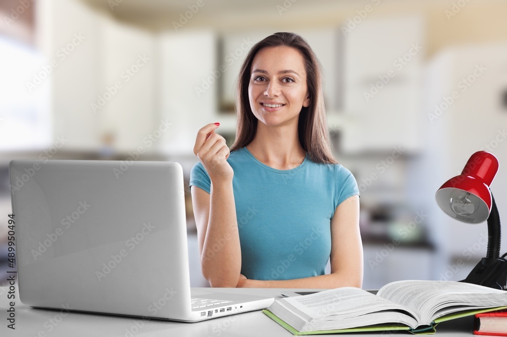 Fototapeta premium Happy young woman student having video call virtual meeting working or remote learning at home