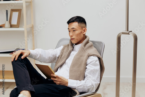handsome man with a tablet sits in a chair communication technologies