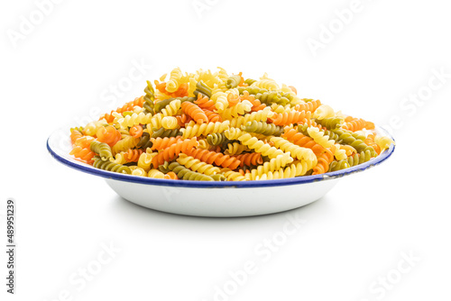 Three colors fusilli pasta in bowl. Colorful italian raw pasta isolated on white background.