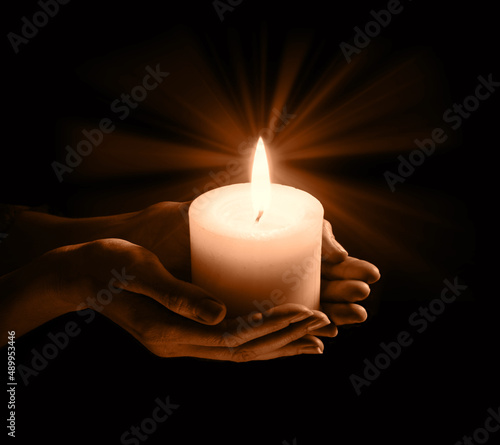 Women's hands holding a candle