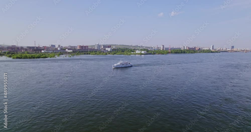 A passenger ship sails down a river A passenger ship sails down a river