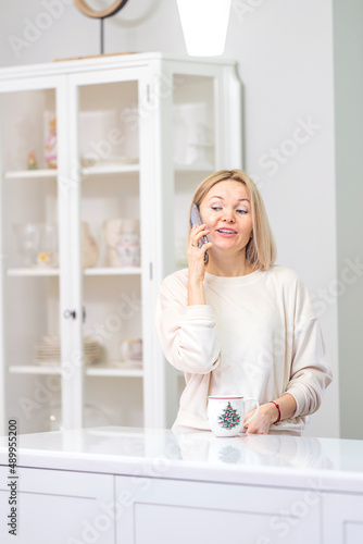 Young beautiful blonde girl at home in the kitchen