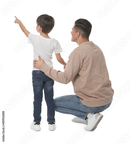 Little boy with his father on white background, back view