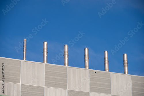 Exhaust pipes on the roof of a modern building.