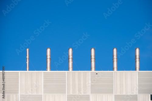 Exhaust pipes on the roof of a modern building.