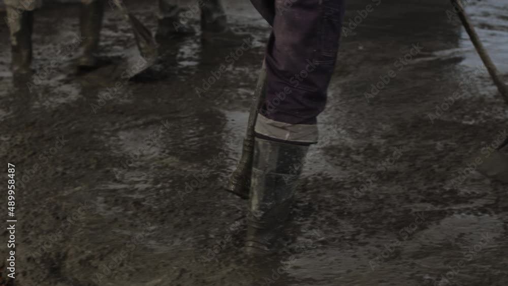 Worker pouring concrete at the construction site. Concrete unloading - close up Worker pouring concrete at the construction site. Concrete unloading - close up