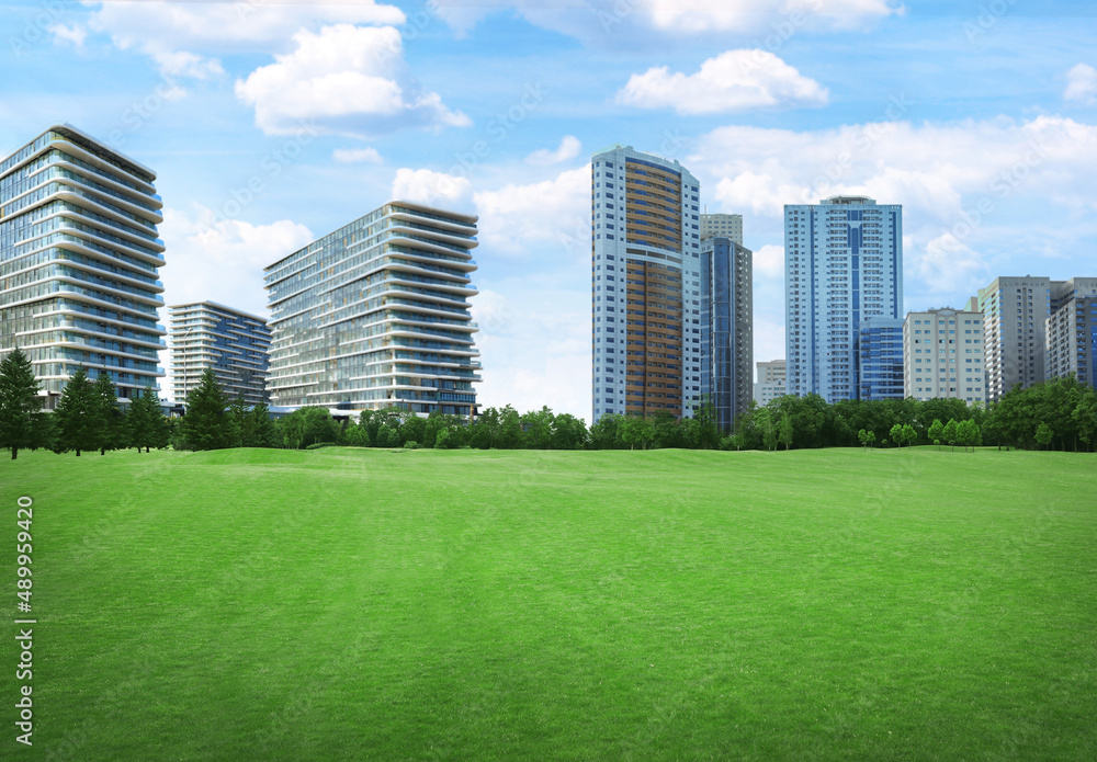 Beautiful view of park with green lawn and cityscape on sunny day Beautiful view of park with green lawn and cityscape on sunny day