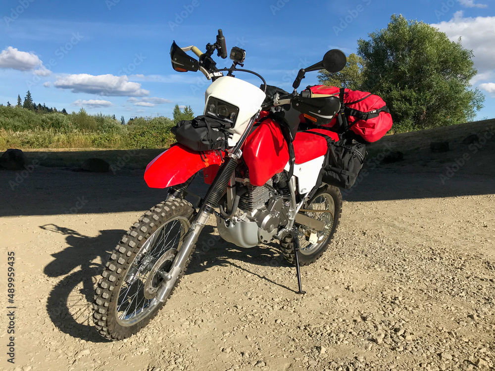 Custom adventure dual sport motorcycle parked on gravel road, no brands or logos