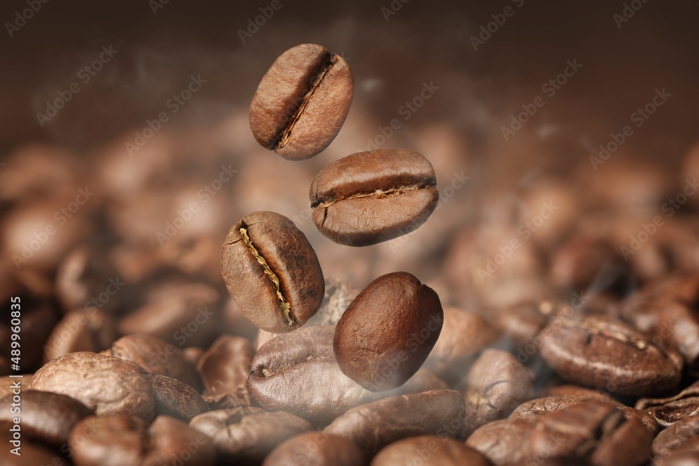 Aromatic roasted coffee beans and steam, closeup Aromatic roasted coffee beans and steam, closeup