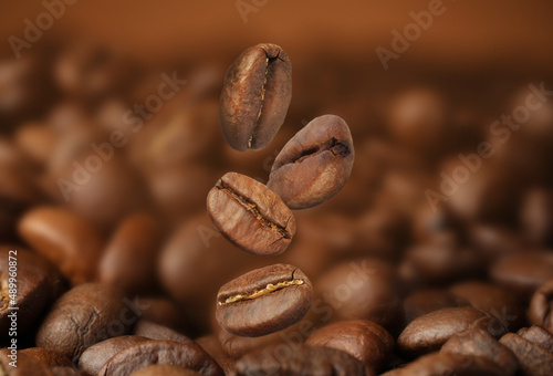 Falling aromatic roasted coffee beans, closeup view