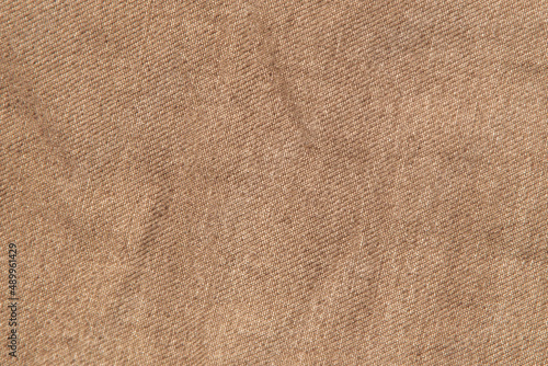 fabric grunge background, real cotton denim brown, wrinkled, frayed, close