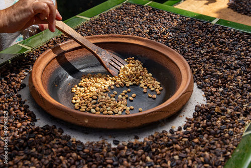 traditional roasting of coffee beans in a clay bowl, roasted beans and green beans