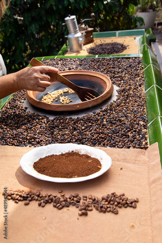 traditional roasting of coffee beans in a clay bowl, roasted beans and green beans