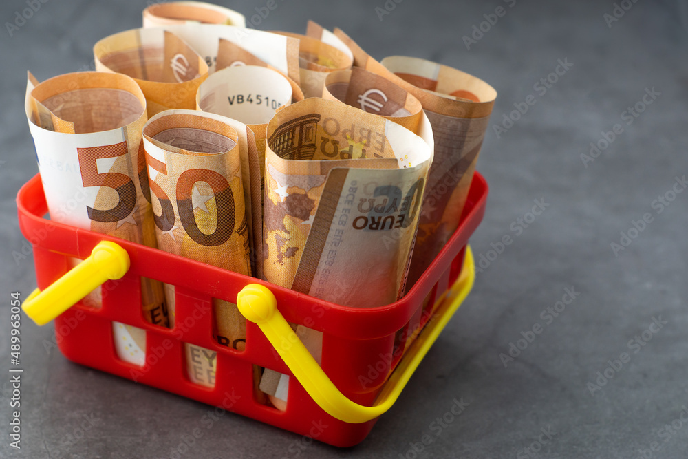 Supermarket basket or shopping cart full of money - 50 euro banknotes. Concept of changing exchange rates of the European currency.