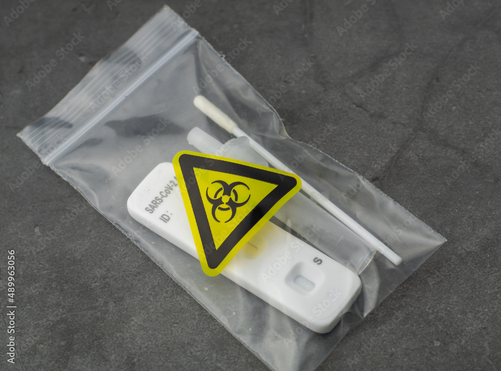 Toxic leftovers after corona speed test in special bag. Coronavirus test put safe with a yellow signed bag.